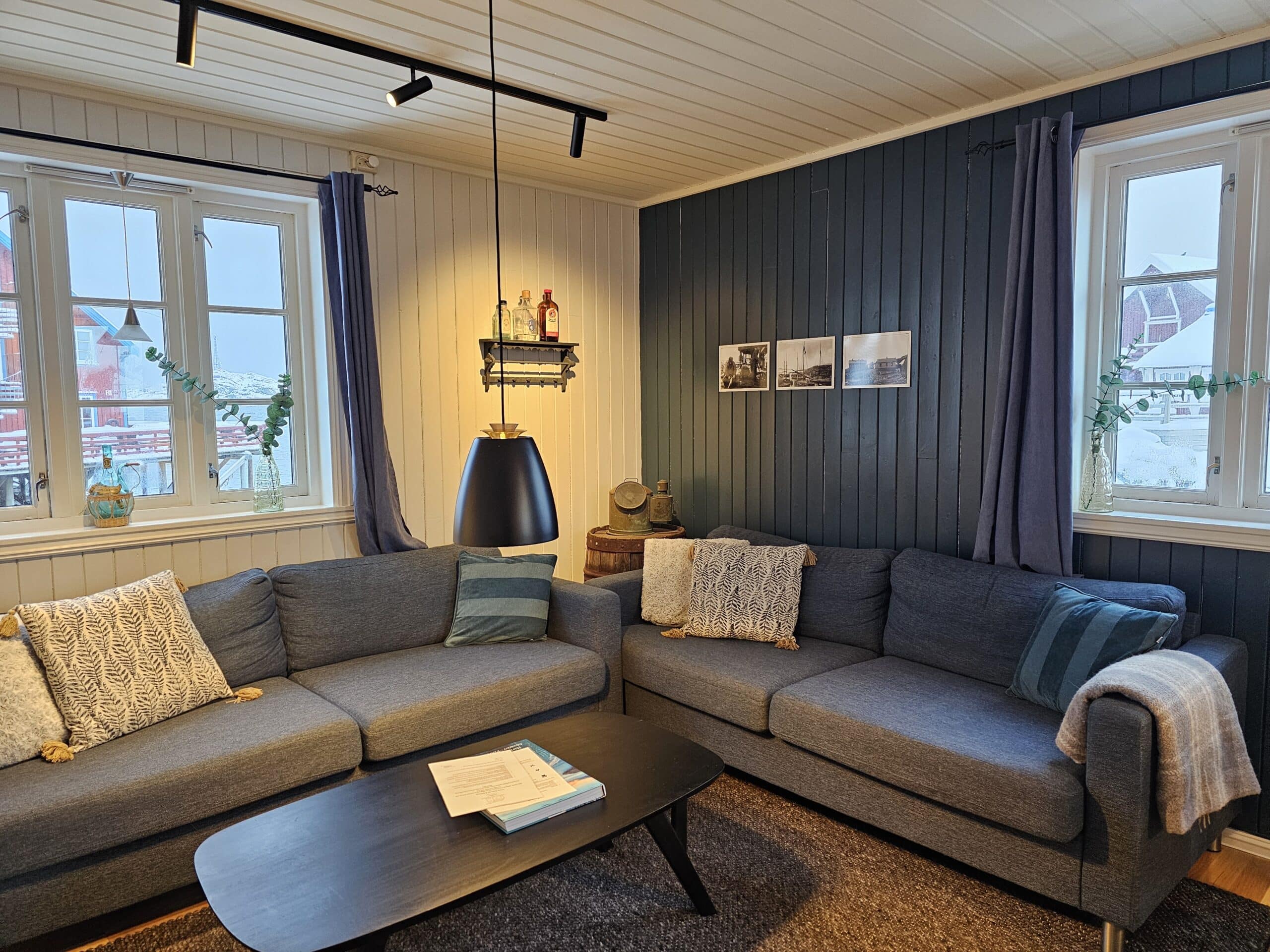 Bright living room with sea view windows in a traditional rorbu cabin.